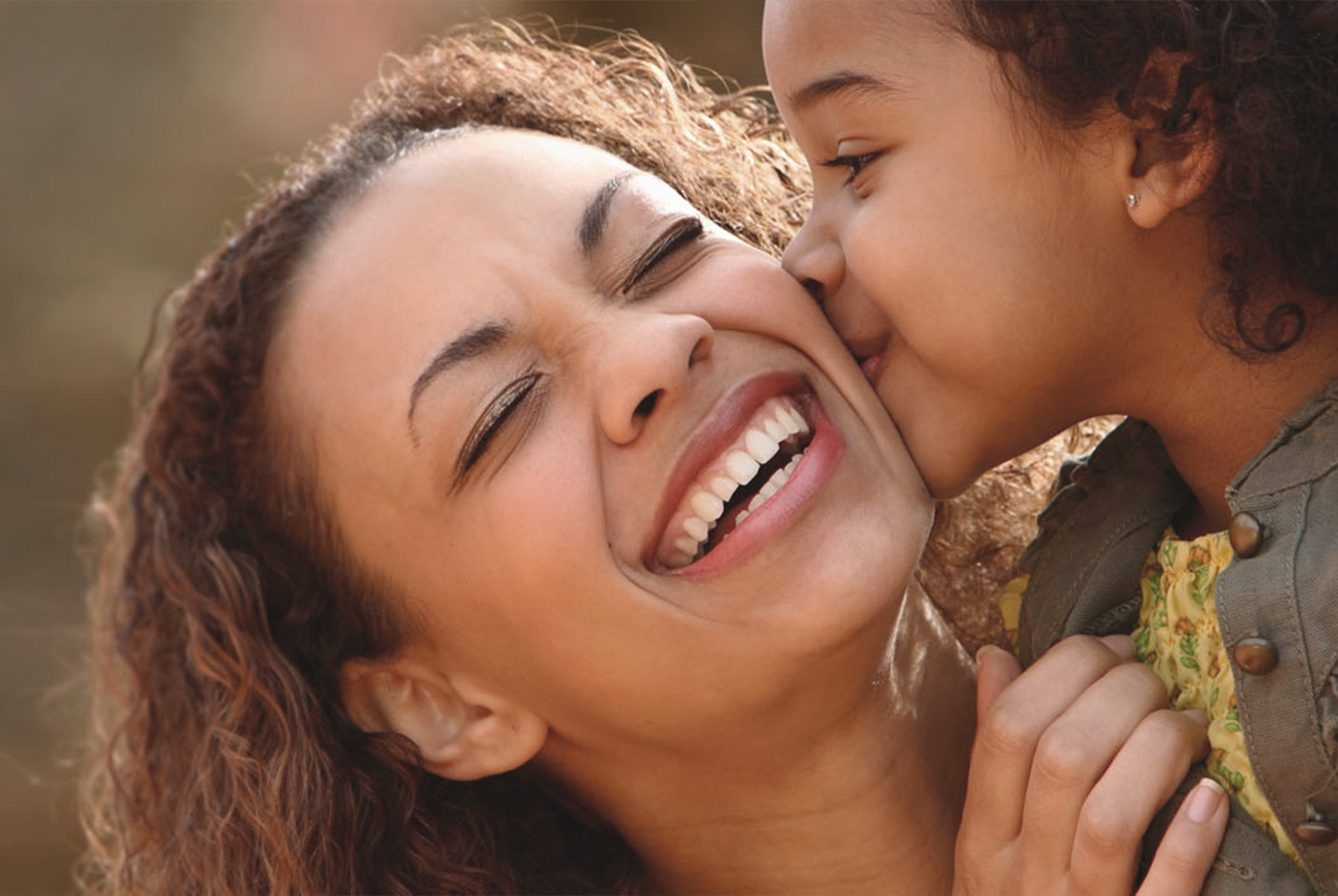 A woman and a child sharing a joyful moment with smiles, capturing an intimate family scene.