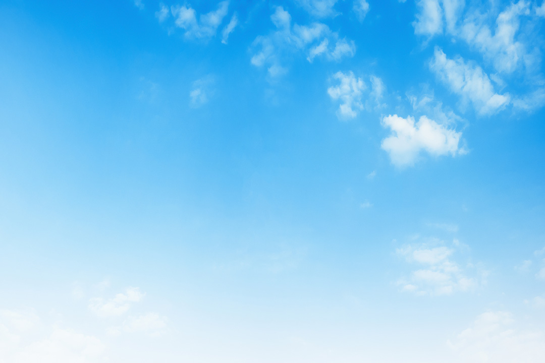 The image is a photograph of a clear blue sky with a few scattered clouds, taken from a low angle looking up.