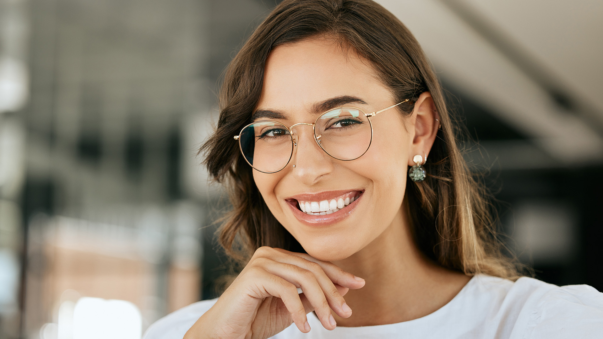 A smiling woman with glasses, posing for a portrait.