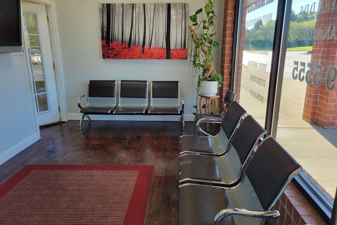 Waiting area with multiple benches, a red rug, and a window view.