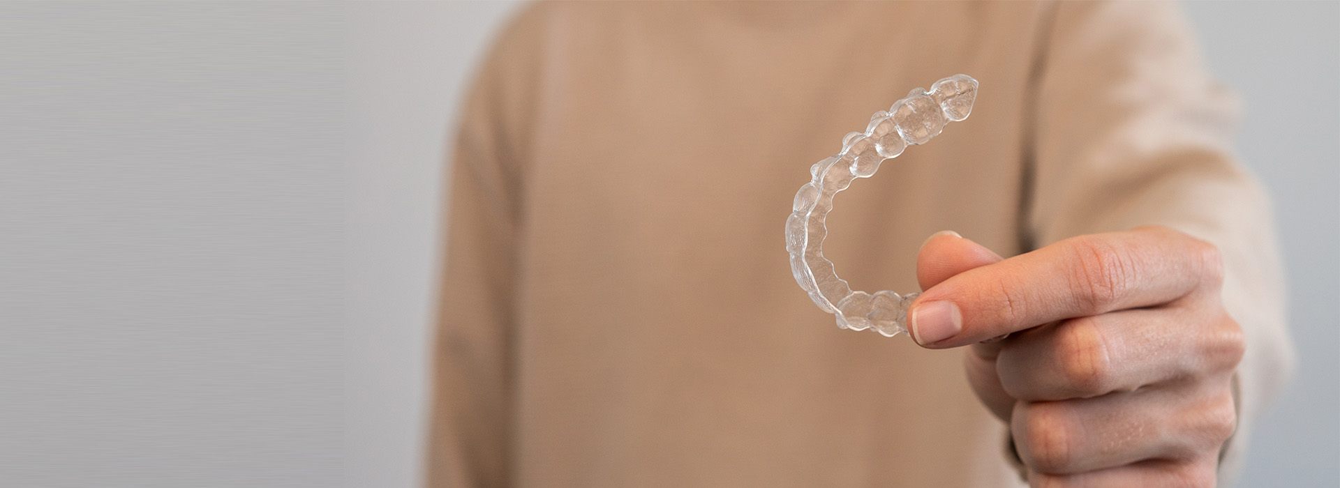 A person s hand holding a soap bubble in front of a white background.