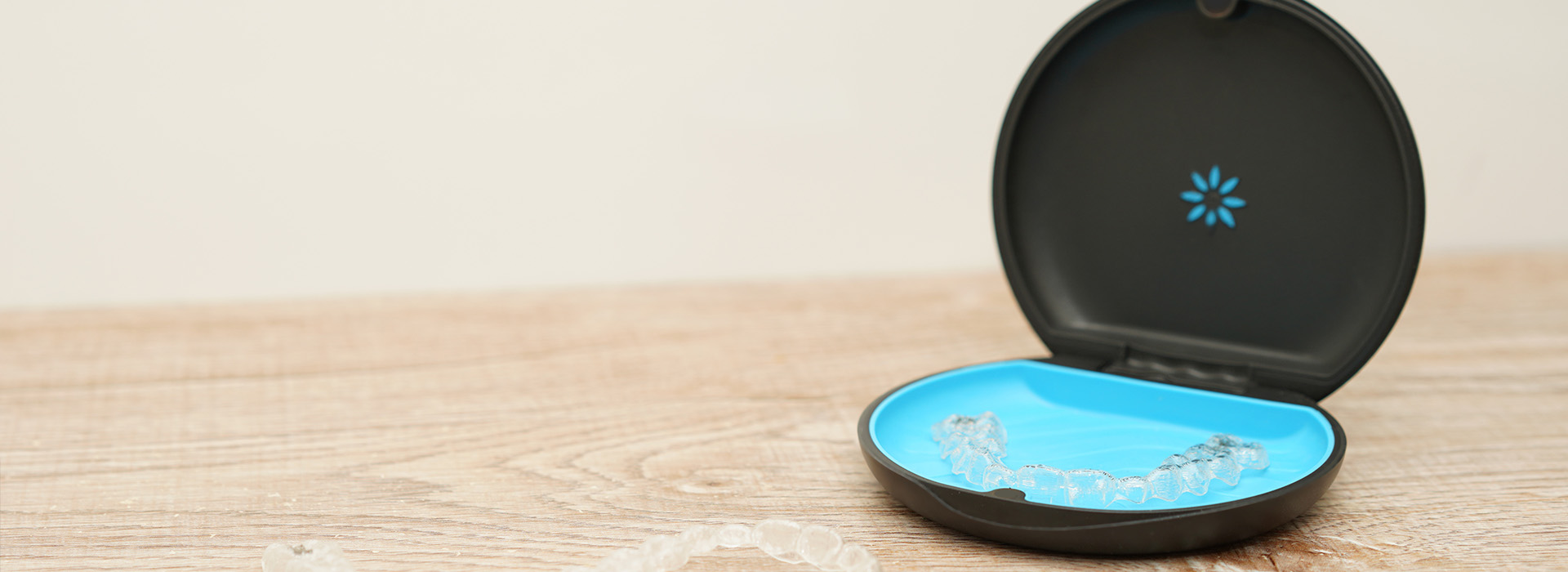 The image shows a smart home device, specifically a voice assistant with a blue light on the front, placed on a flat surface against a white background.