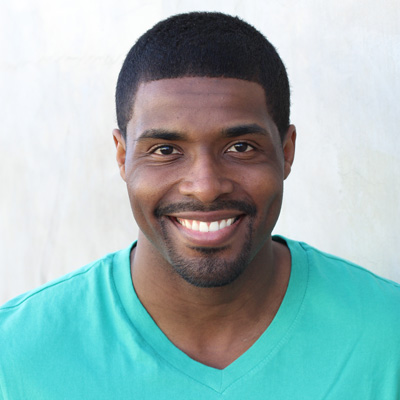 Two elderly people, a man and a woman, smiling closely together in a warm embrace.