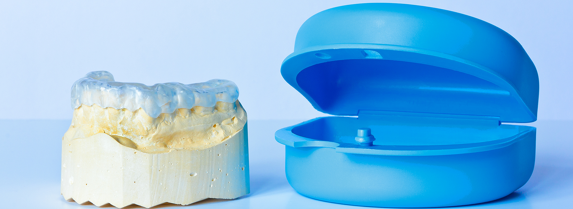 Dental implant and blue plastic model for educational purposes.